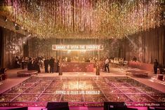 a large room filled with lots of tables covered in pink and gold confetti