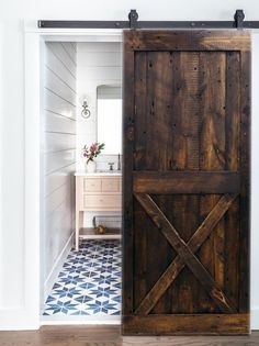 an open door leading to a bathroom with blue and white tile flooring on the walls