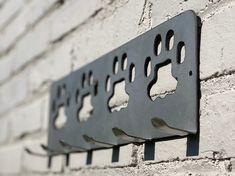 three metal brackets on the side of a brick wall