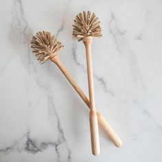 two wooden brushes sitting on top of a marble counter