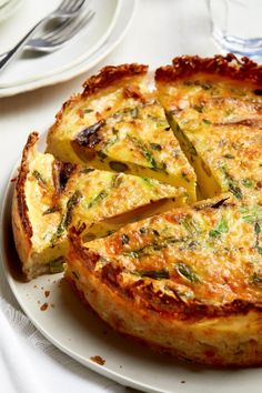 a quiche on a white plate with silverware