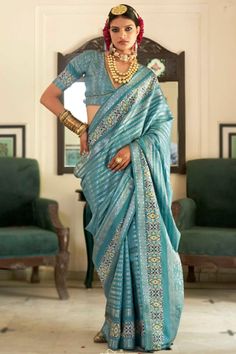 Enhance your ethnic charm by wearing this teal blue silk saree which makes you appealing.This v neck and half sleeve blouse is printed and woven zari work.It is accompanied by a matching silk lightweight saree in teal blue color prettified with printed and woven zari work.This blouse can be customized up to the maximum size available in inches 44 around the bust. Slight color variation may occur due to photographic reasons. Modest Blouse, Blue Silk Saree, Teal Blue Color, Half Sleeve Blouse, Zari Work, Blue Silk, Half Sleeve, Teal Blue, Silk Saree