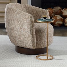 a chair sitting on top of a white rug next to a table with a cup