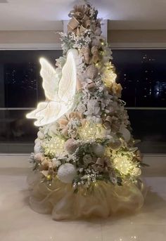 a decorated christmas tree with angel wings and ornaments on it's sides in a lobby