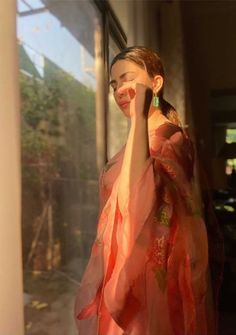 a woman in a kimono looking out the window