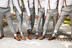 a group of men standing next to each other wearing ties and dress shoes with socks on them