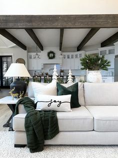 a living room filled with white furniture and christmas decorations