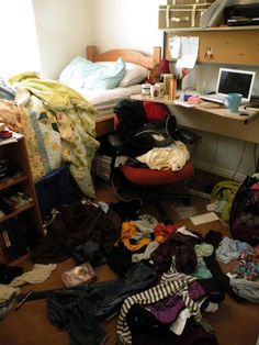 a messy bedroom with clothes scattered all over the floor and on the desk, computer monitor, bookshelf and bed