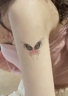 a woman with a butterfly tattoo on her arm