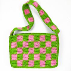 a crocheted green and pink purse on a white background