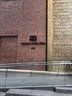 the entrance to an old brick building with metal handrails and stairs leading up to it