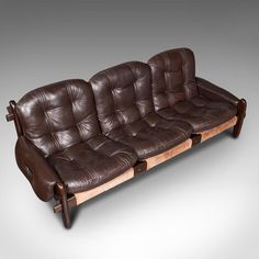 a brown leather couch sitting on top of a wooden frame