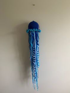 a blue hat hanging from the side of a wall