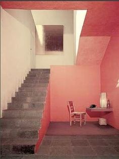 there is a small table and two chairs on the stairs in this room with pink walls