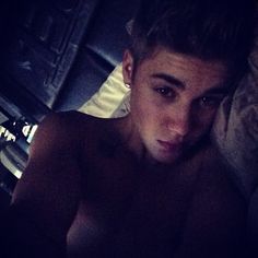 a shirtless young man laying in bed with the words good night on his chest