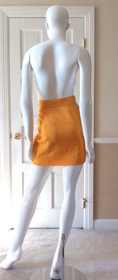 "This vintage Moschino skirt is in his iconic taxi cab/school bus yellow. Fully lined in yellow rayon. Side zipper with self button. Front and back shaping seams. Measurements - Waist - 27' Hips - 36\" Length - 18\"" Fitted Yellow Skirt For Fall, Chic Fitted Yellow Pencil Skirt, Chic Yellow Fitted Pencil Skirt, Fitted Orange Skort, Chic Fitted Orange Mini Skirt, Chic Fitted Yellow Skirt, Fitted Orange Mini Skirt For Fall, Yellow Skirt For Workwear In Fall, Orange Fitted Retro Mini Skirt