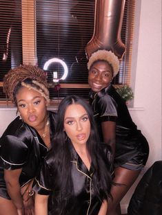 three women dressed in black posing for the camera