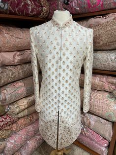 Beige cream raw silk sherwani blooms with fine floral jaal pattern charmed with resham thread and highlighted in gold stone and pearl embroidery. Available with matching chudidar. Size: 40/M Occasion: Wedding Ceremony or Reception WASH CARE INSTRUCTIONS - Please Dry clean only when it is applicable. Slight color variation is possible due to digital photography. Ready to Ship! Ceremonial Clothing, Pearl Embroidery, Hrithik Roshan, Gold Stone, Extra Fabric, Churidar, Raw Silk, Digital Photography, Shoulder Sleeve