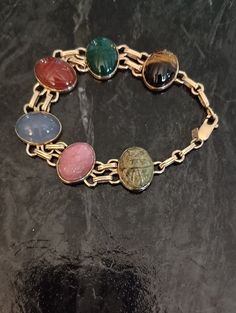 Gorgeous bright 14K yellow gold genuine semiprecious gem scarab double link bracelet. Signed WRE 14KT.  Excellent vintage condition. 6 beautiful stones: red carnelian, pink rhodochrosite, lavender blue agate, tiger eye, unakite, and green chalcedony. Clearly marked 14KT WRE on permanently attached hang tag. Lobster clasp marked 14K, works smoothly and holds firmly.  Well made fine bracelet. All the links are soldered permanently together. There is no mistaking the silky feel of 14K and high level craftsmanship WRE is known for. This is a beautiful, exemplary bracelet anyone would be proud to own and enjoy. Antique Oval Gemstone Bracelets, Gold Oval Bracelets, Unique Oval Gold Bracelets, Scarab Bracelet, Pink Rhodochrosite, Red Carnelian, Green Chalcedony, Lavender Blue, Blue Agate