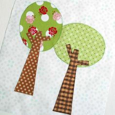 a table runner with two trees on it and one tree in the middle, next to a small pine cone