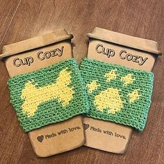 two crocheted cup cozys sitting on top of a wooden table