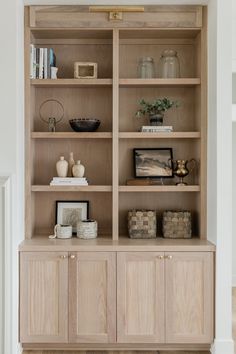 a wooden bookcase filled with lots of books and vases on top of it