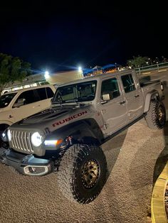 two jeeps parked in a parking lot with lights on at the top and bottom