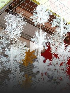 snowflakes are hanging from the ceiling in front of a red and yellow building