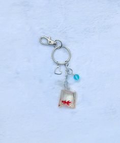 a keychain with a fish charm hanging from it's side in the snow