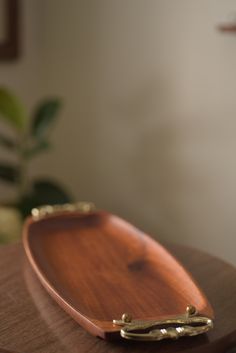 a wooden tray sitting on top of a table next to a potted green plant