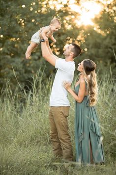 a man holding a baby up in the air