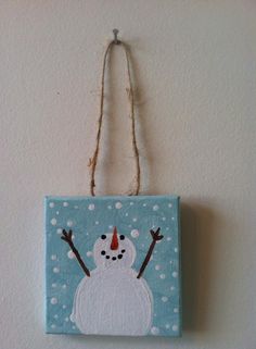 a snowman hanging on the wall with his arms in the air