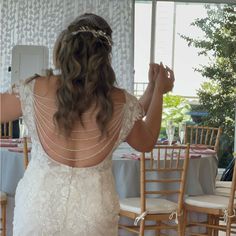 the back of a bride's dress as she stands in front of a table