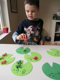 a little boy that is standing in front of a table with some cut outs on it