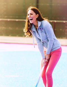 the young woman is playing hockey on the field