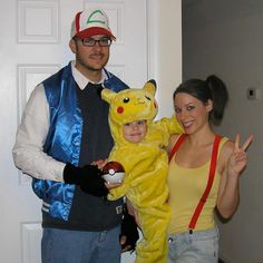 a man and woman in pokemon costumes posing for the camera with a child dressed as pikachu