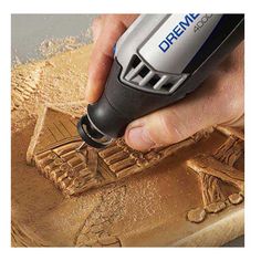 a person using a power tool to cut out the design on a piece of wood