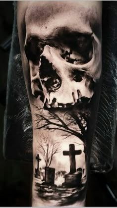 a man's arm with a skull and graveyard scene on it