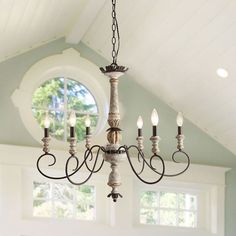 a chandelier hanging from the ceiling in a room with white walls and windows