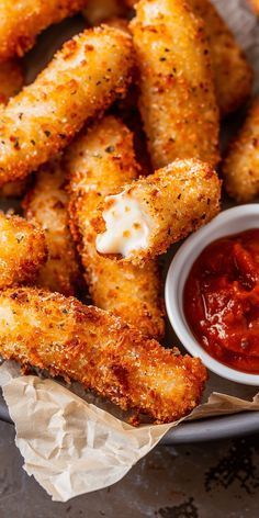 some fried food is on a plate with ketchup and mayonnaise sticks