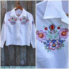 "Vintage 1960's or 1950's blouse. Hungarian made (no tag but I bought with another shirt that was). Has beautiful embroidery and carved mother of shell buttons. Good condition - one VERY light stain on front, it was so light I couldn't get it to show up in a picture. / / / / / / MEASUREMENTS: / / / / / / (all were taken while laying flat - double where necessary) ESTIMATED size: Medium (this is a GUESS...please use measurements!) CHEST (armpit to armpit): 20\" SHOULDER (seam to seam): 14.5\" LEN Vintage Collared Shirt With Floral Embroidery, Vintage Embroidered Button-up Shirt, Retro Embroidered Collared Top, Retro Collared Embroidered Top, Retro Embroidered Button-up Top, White Embroidered Vintage Blouse, Vintage Embroidered Collared Blouse, Vintage Embroidered Spring Shirt, Retro Floral Embroidered Button-up Top