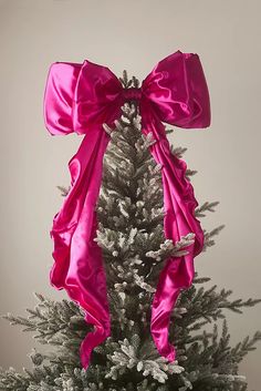 a white christmas tree with pink bows on it