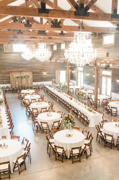 a large room with tables, chairs and chandeliers set up for an event