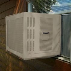 an air conditioner mounted on the side of a house next to a windowsill