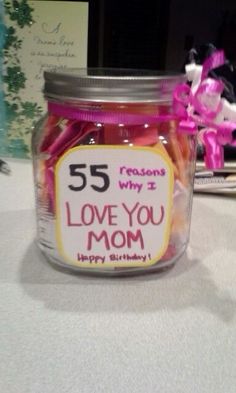 a jar filled with lots of candy sitting on top of a table next to a card