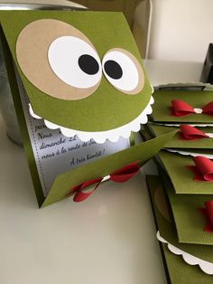 a close up of a card with a frog on it's face and red bows around its neck