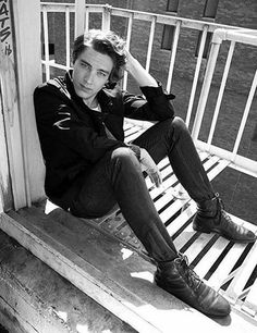 a man sitting on top of a wooden bench