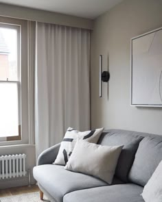 a gray couch sitting next to a window in a living room