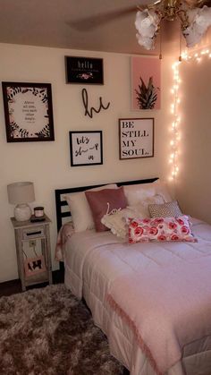 a bedroom with lights strung from the ceiling and pictures on the wall above the bed