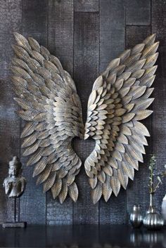 a metal angel wings on a wooden wall